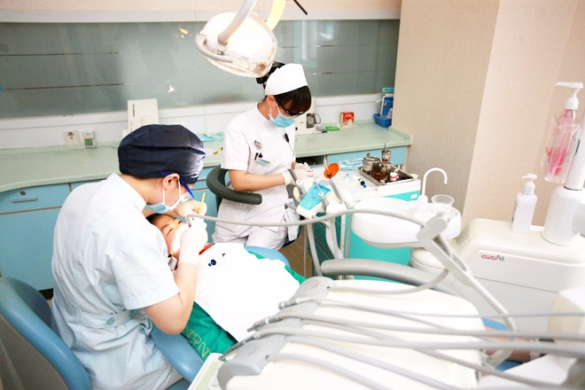 仁爱口腔科为农民工学生看牙-口腔科医生在给学生检查牙齿